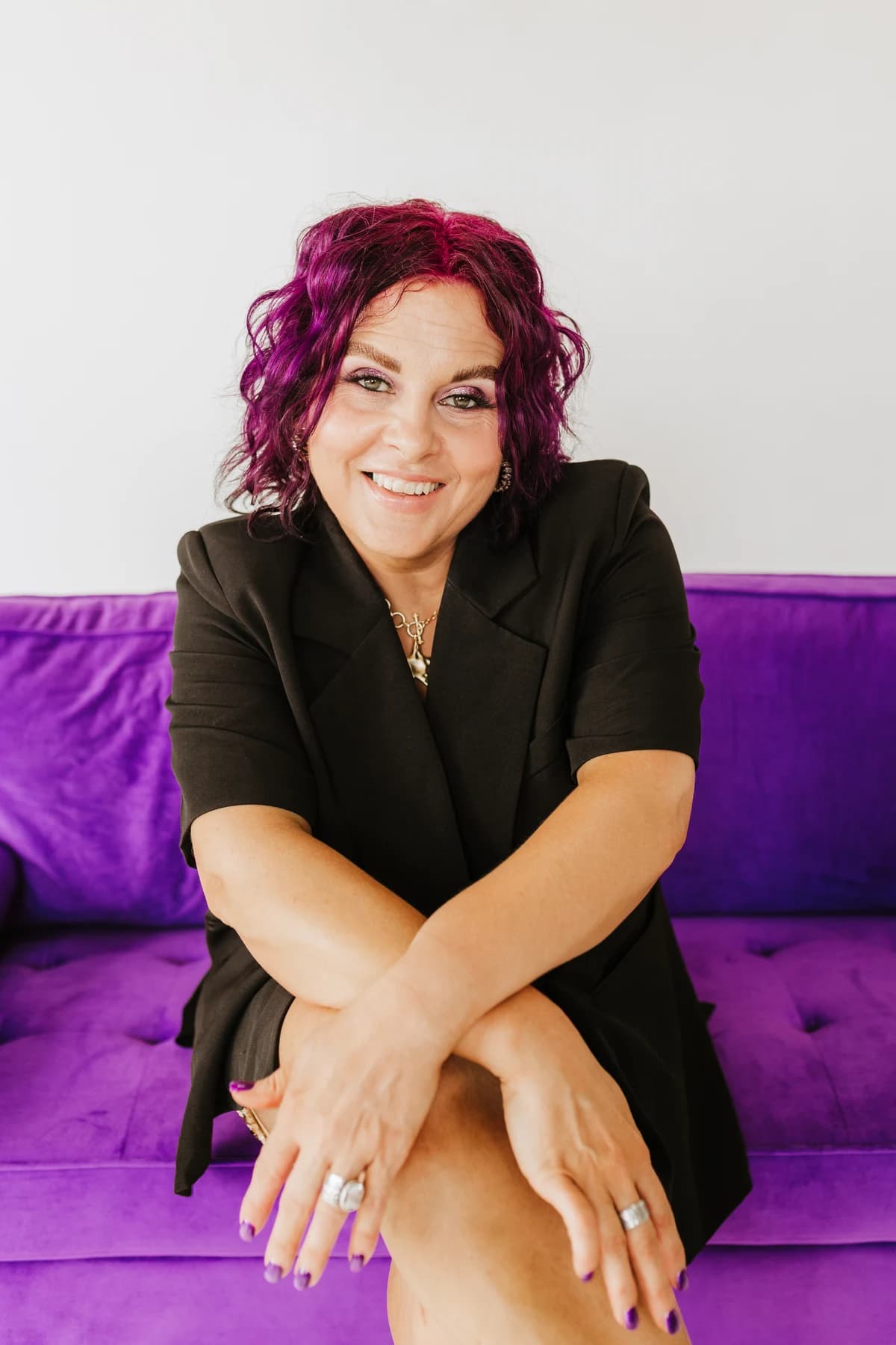 Courtney smiling while seated on the purple couch